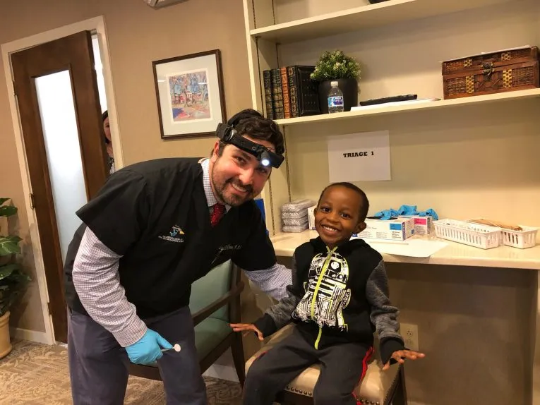 Dr. D'Amico & a pediatric patient in dental chair smiling