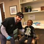 Dr. D'Amico & a pediatric patient in dental chair smiling